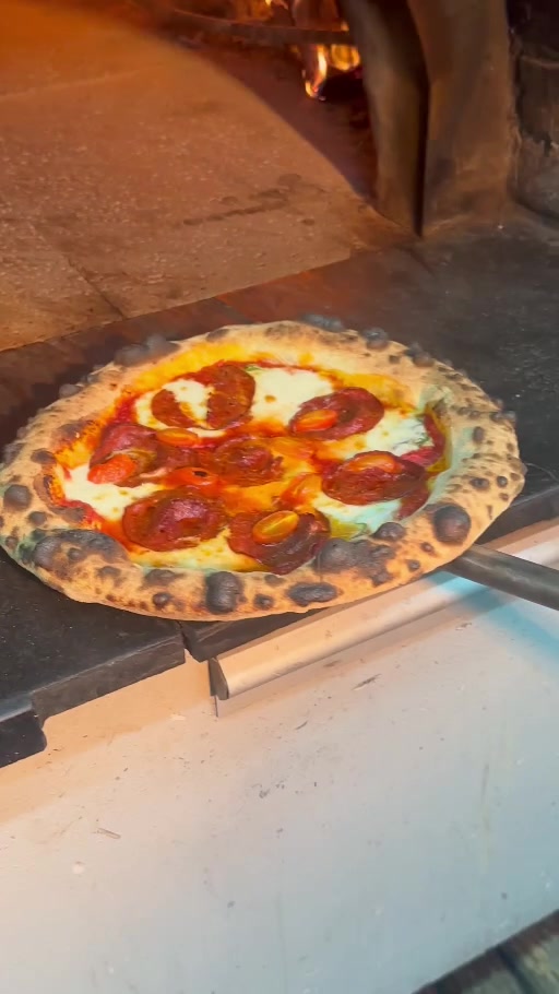 No1 Culinaria’nın odun fırını önünde kürek üzerindeki pepperoni pizza